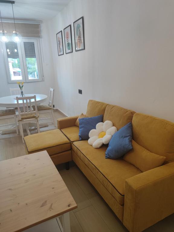 a living room with a brown couch with blue pillows at Apartamento Buen Recuerdo in Camarena de la Sierra