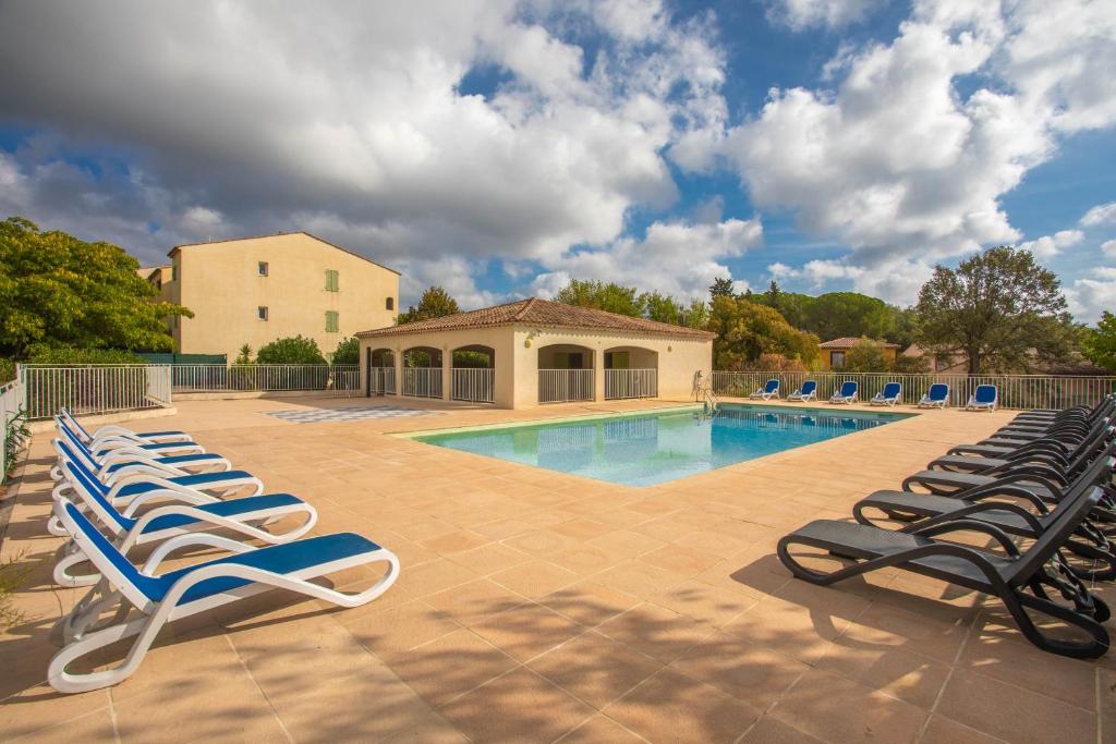 een groep ligstoelen naast een zwembad bij Appartement Le Plan de La Tour in Plan-de-la-Tour
