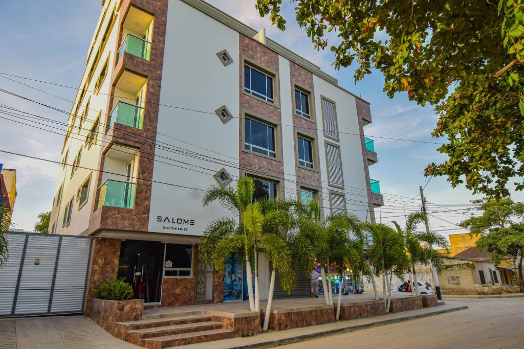 un edificio con palme di fronte ad esso di Ayenda Salome Apartments a Cartagena de Indias