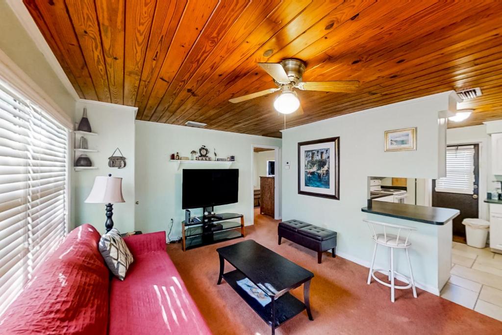 een woonkamer met een rode bank en een flatscreen-tv bij Lake June Resort #10 in Lake Placid