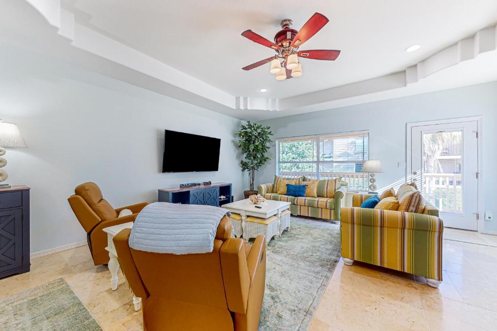 a living room with a ceiling fan and a couch at Sunset Over Paradise in South Padre Island