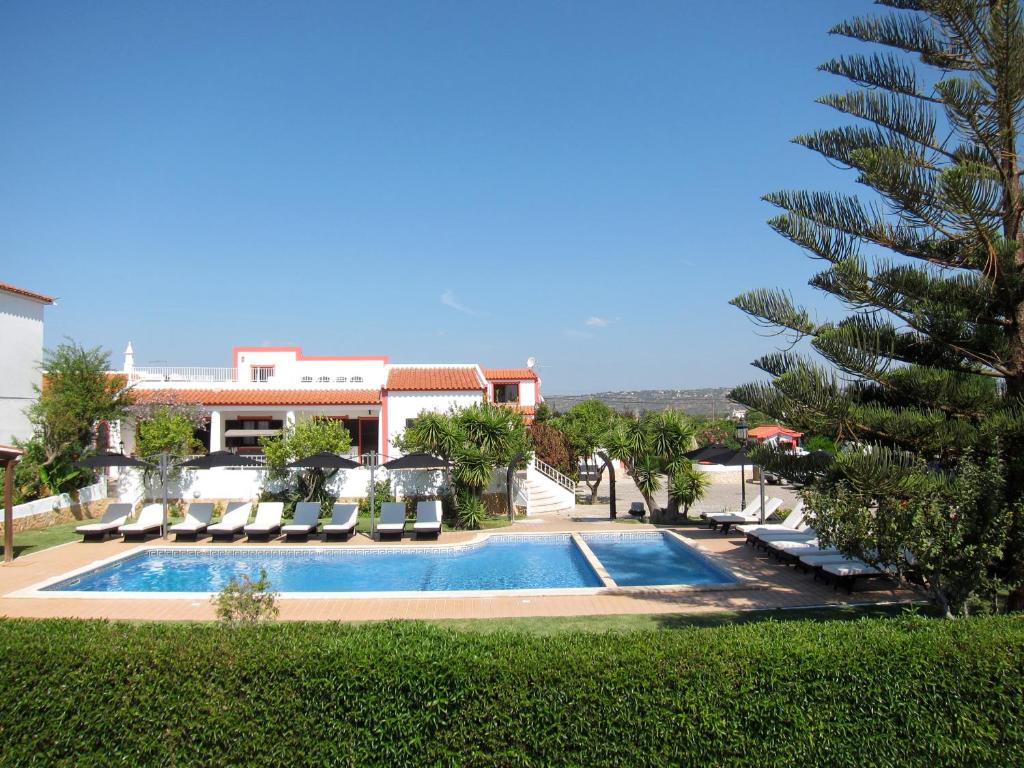 una piscina con tumbonas y una palmera en Casa da Horta, Vale carro Olhos de Agua, en Albufeira