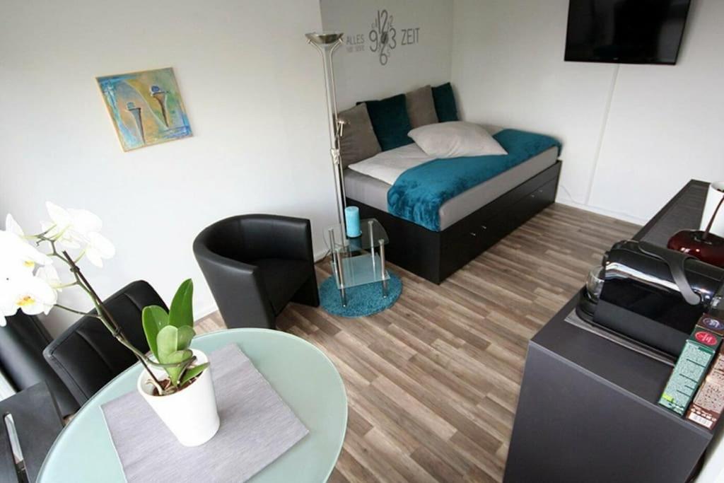 a small room with a bed and a table at Moderne Wohnung mit Wellnessdusche und Strandkorb in Braunschweig