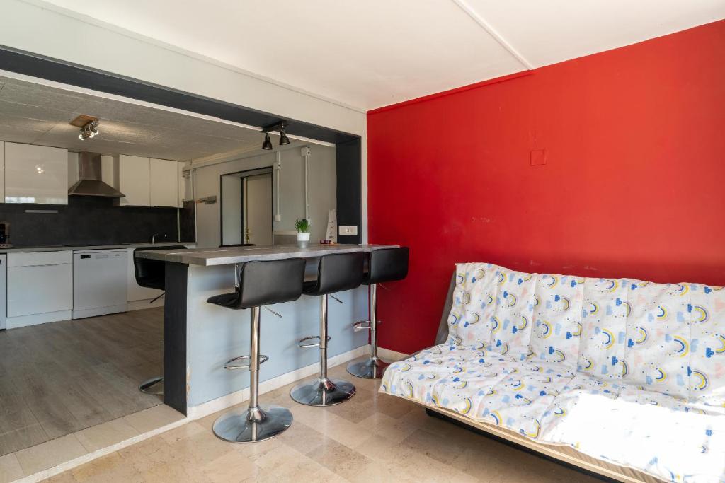 a kitchen with a bar and a couch in a room at Maison des Charmettes in Nîmes