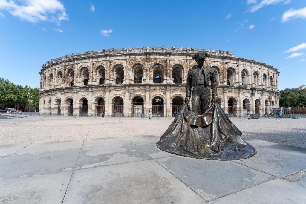 a statue of a woman in front of a building at Maison des Charmettes in Nîmes