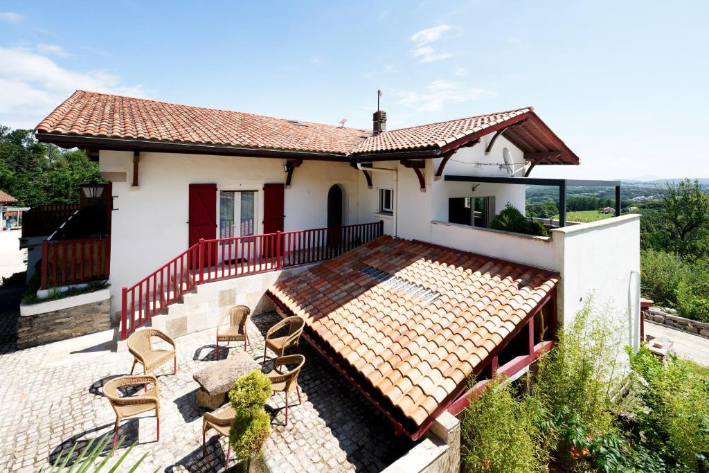 a house with a patio with chairs and a roof at Appart 12 pers 5km plage Hendaye in Urrugne