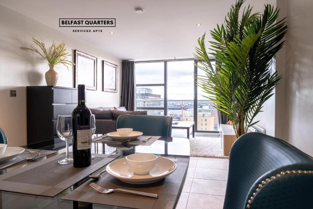 a living room with a table with a bottle of wine at Belfast Quarters: 10th Floor Gem in Belfast