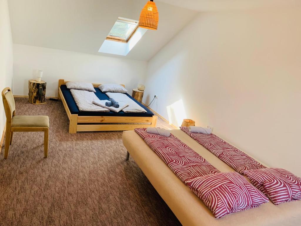 ein Schlafzimmer mit einem Bett und einem Stuhl darin in der Unterkunft Home of arts and creation, Erdei alkoto studio in Kismaros