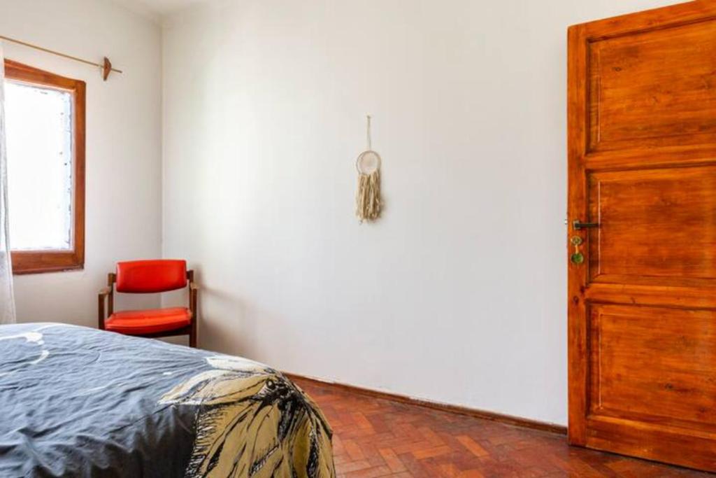 a bedroom with a bed and a red chair at La Juana Mza in Guaymallen