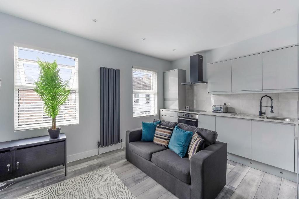 a living room with a couch and a kitchen at Elegant Croydon Apartment in London