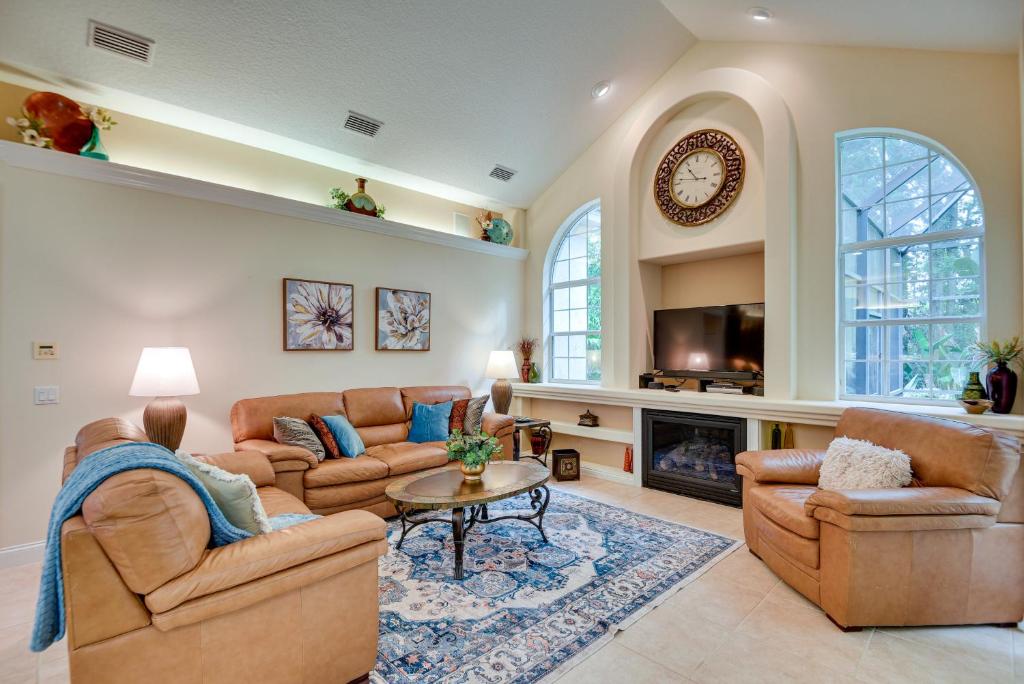 a living room with two couches and a fireplace at Breezy Palm Coast Golf Retreat with Pool and Lanai! in Palm Coast