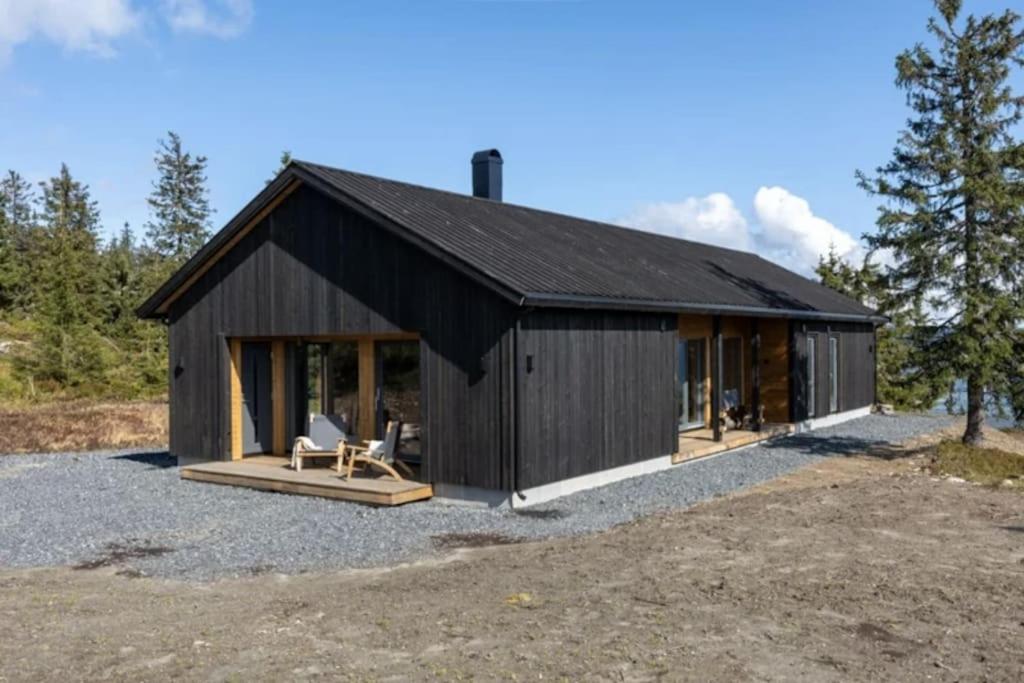 una casa con tetto nero e patio di Unique new cabin by Hafjell & Skei with stunning view a Tretten