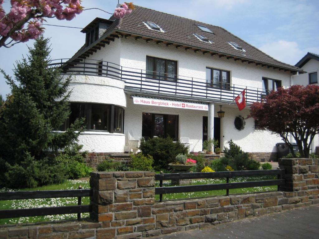 ein weißes Haus mit einem Zaun davor in der Unterkunft Hotel Haus Bergblick in Rheinbreitbach