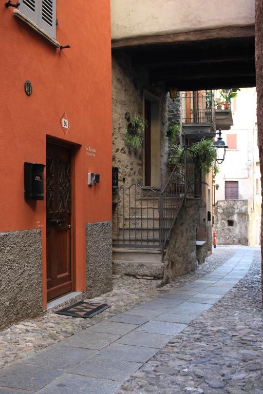 an orange building with a door and stairs on a street at Casa Violetta, Historic Center in Colonno