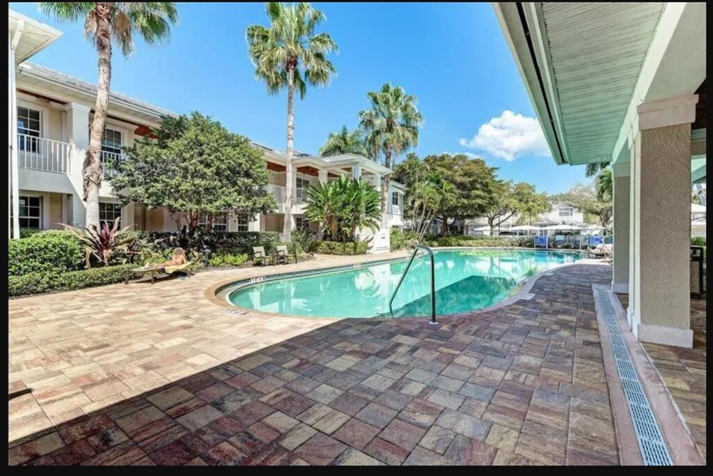 a swimming pool in front of a house with palm trees at 1 bedroom (2 Beds), 1 Bath with Kitchen at IMG in Bradenton