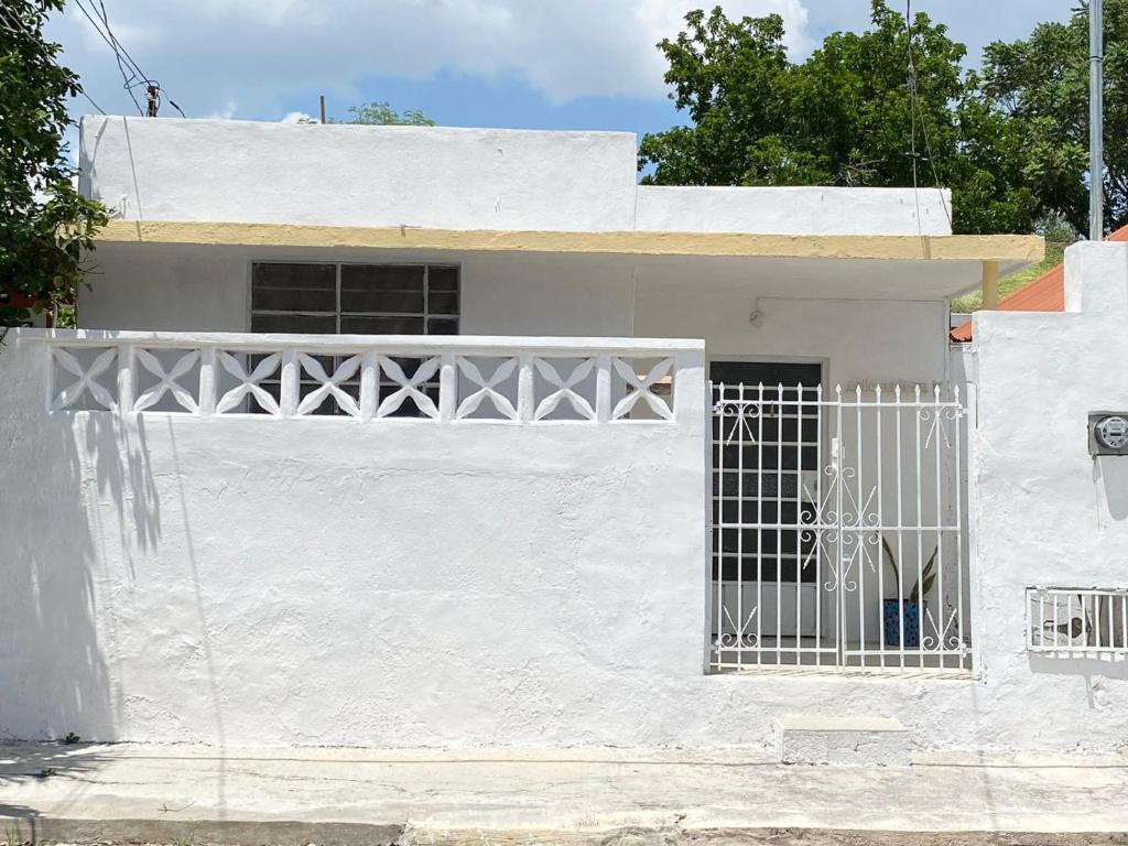 une maison blanche avec une porte en face dans l'établissement La casa de las muñecas, à Mérida