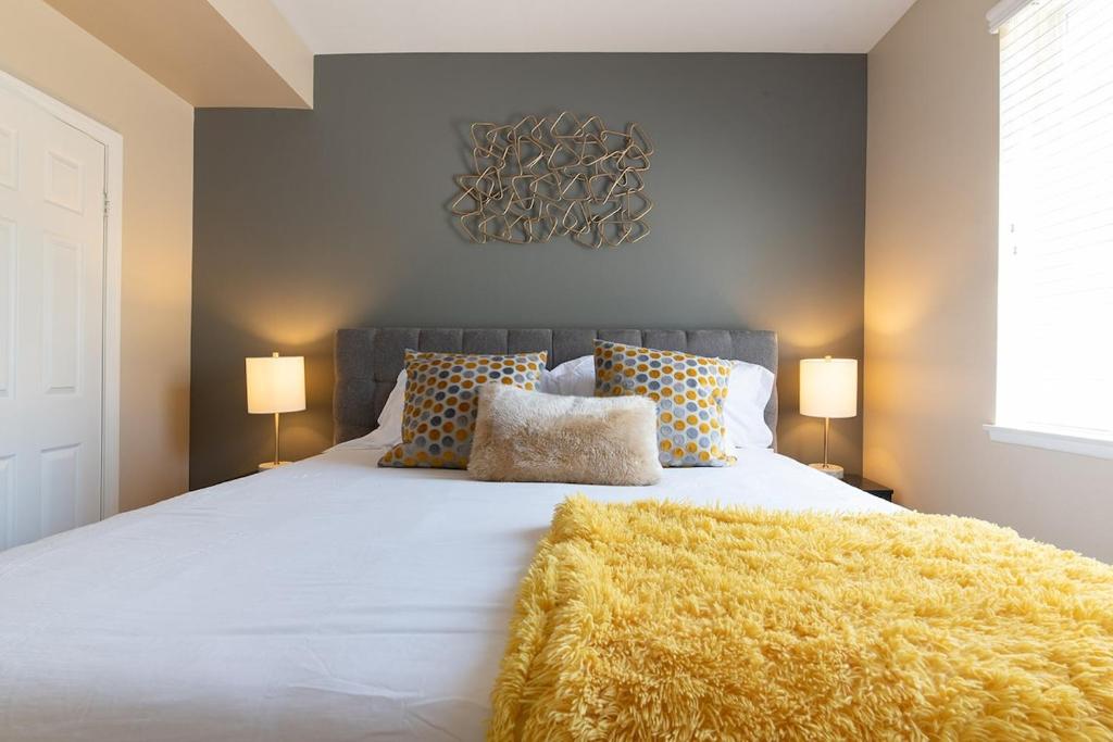 a bedroom with a large white bed with a yellow blanket at Modern Suitevipwifipool2 King Bedsac in Santa Clarita