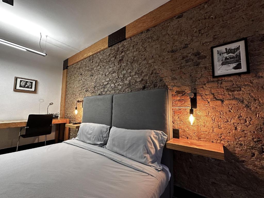 um quarto com uma cama com uma parede de tijolos em Casa Corazon em Guadalajara