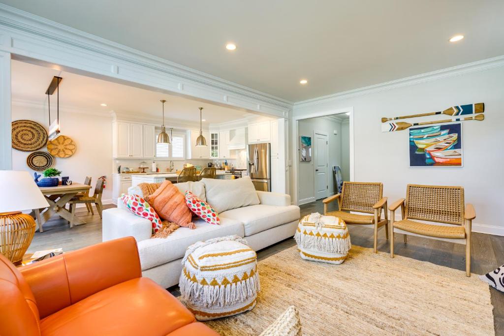 a living room with orange furniture and a kitchen at Sleek Long Branch Vacation Rental with Yard and Patio! in Long Branch