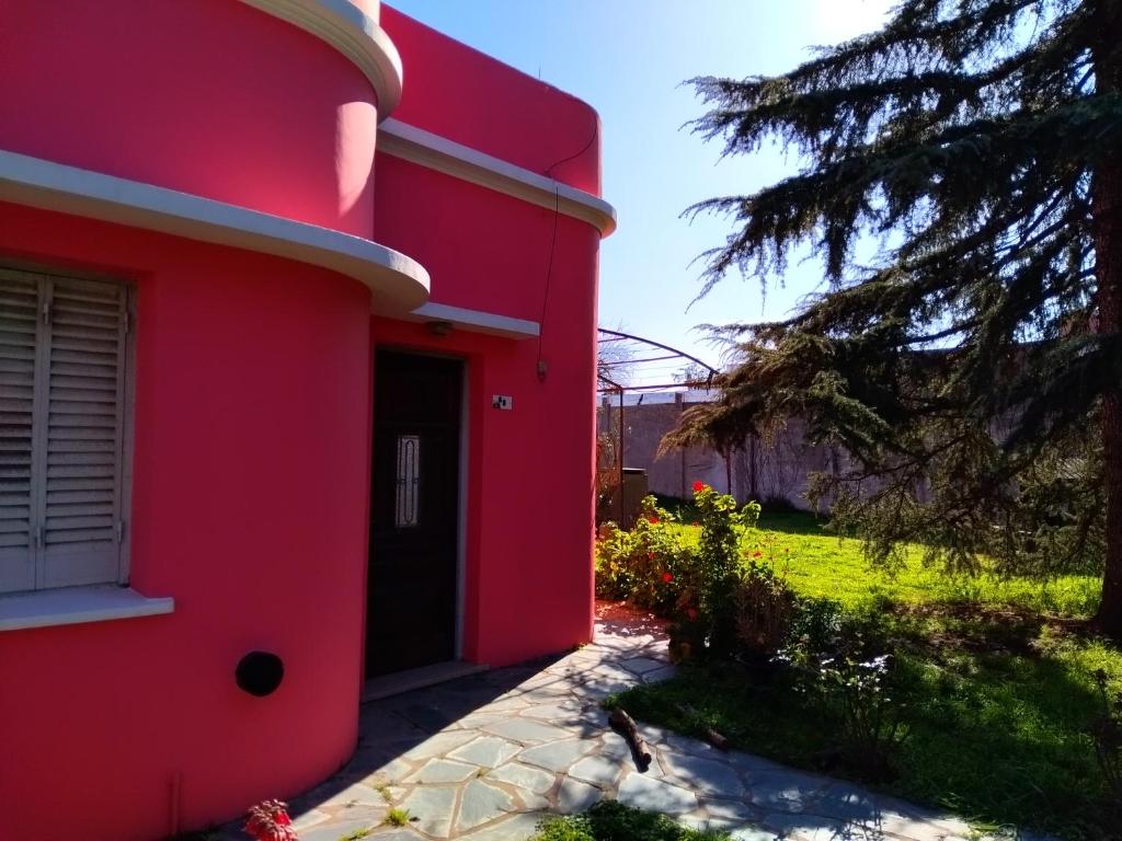 una casa roja con una puerta negra en un patio en Family Place II en Luján