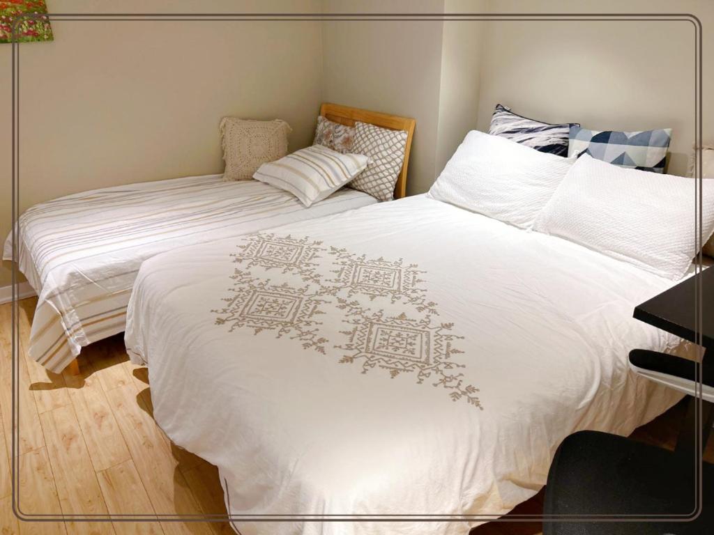 多倫多的住宿－toronto midtown spacious room，一间卧室配有两张带白色床单的床和钢琴