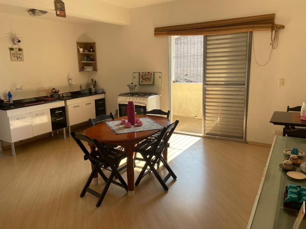 - une cuisine avec une table et des chaises dans la chambre dans l'établissement Hostel Salus, à Barueri