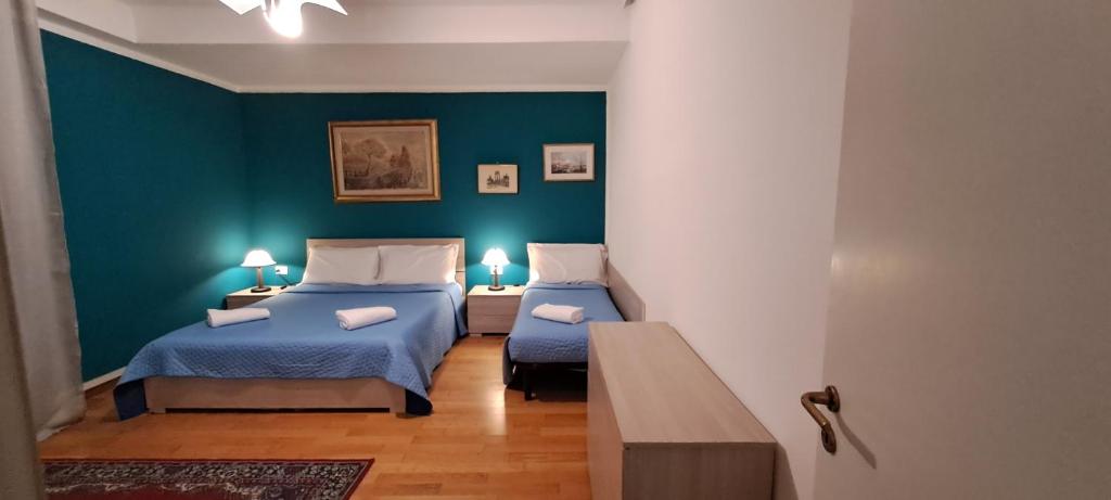 2 Betten in einem Zimmer mit blauen Wänden in der Unterkunft BAROKA HOUSE Venice in Mestre