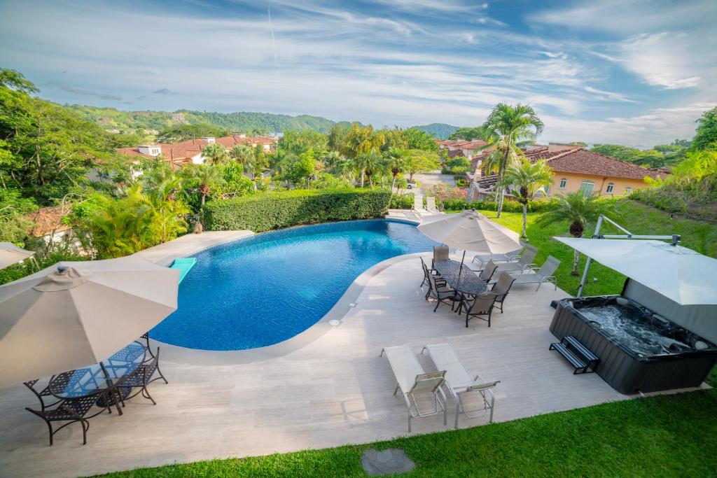 una vista aérea de una piscina con sillas y sombrillas en Los Suenos Resort Casa Patron by Stay in CR, en Herradura