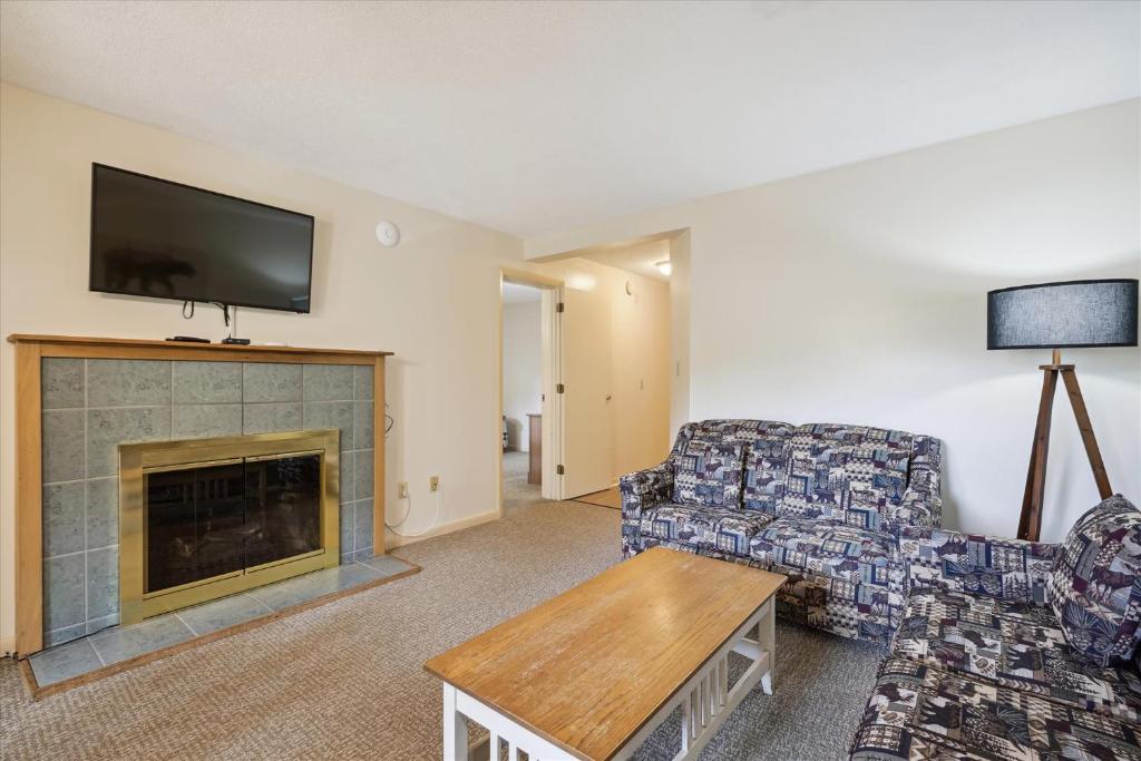 a living room with a couch and a fireplace at Cedarbrook Deluxe Two Bedroom Suite, With heated pool 10102 in Killington