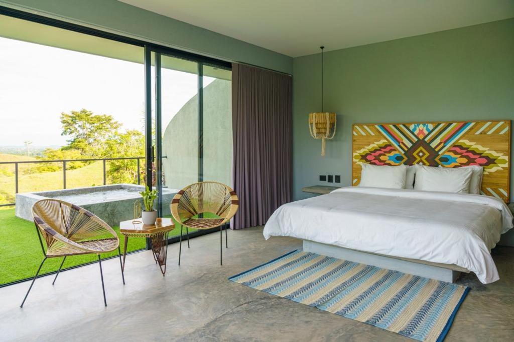 een slaapkamer met een groot bed en een balkon bij Hotel Piedra Mulata - Adults Only in Doradal