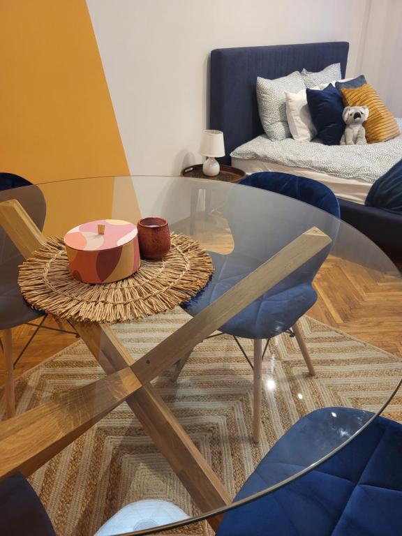 - une table et des chaises en verre dans le salon dans l'établissement Koala Apartman Székesfehérvar, à Székesfehérvár