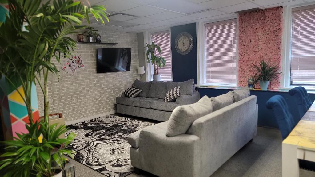 a living room with two couches and a tv at Planet M Hostel in Niagara Falls