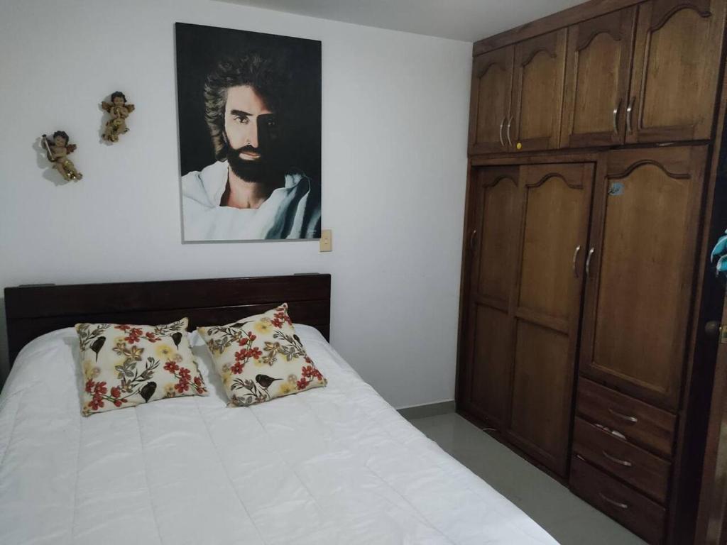 a bedroom with a bed and a painting on the wall at La Pamela in Medellín