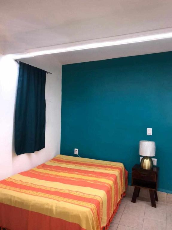 una camera con letto e parete blu di San Fernando Hostal a Città di Oaxaca