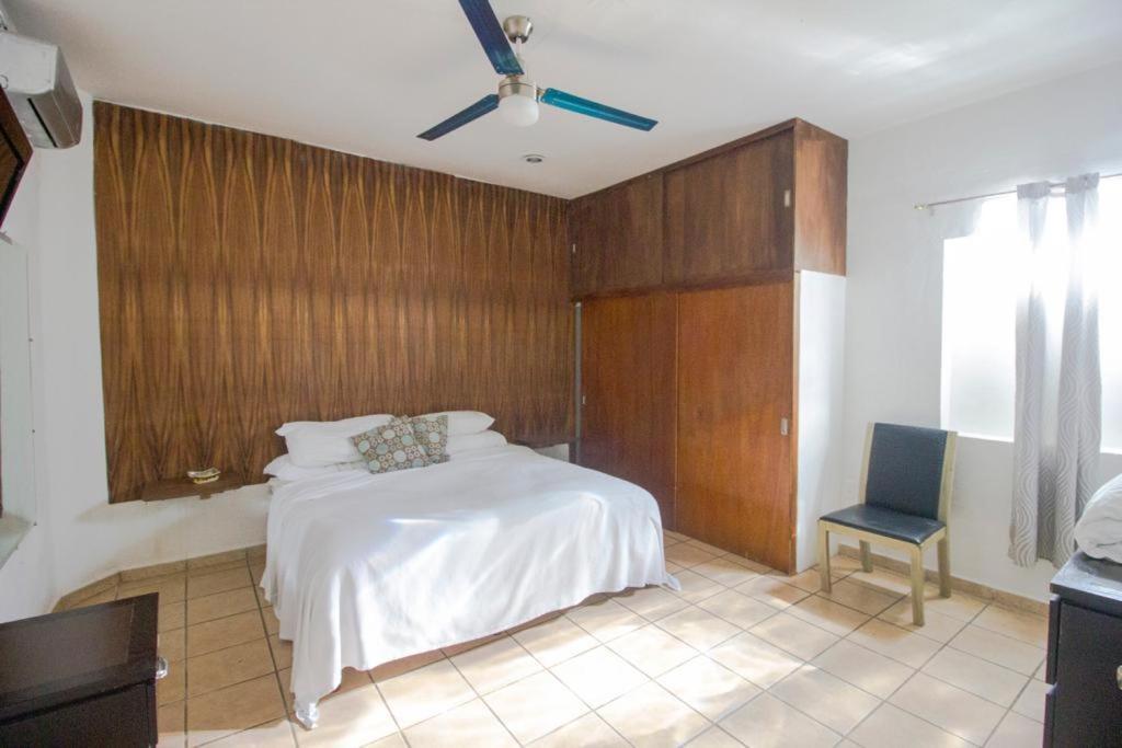- une chambre avec un lit blanc et une chaise bleue dans l'établissement 3 Departamentos con 5 Habitaciones en Zona Romántica, à Puerto Vallarta