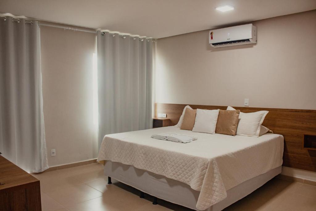 a bedroom with a large bed with a white blanket at Pousada Chayenne in Piranhas