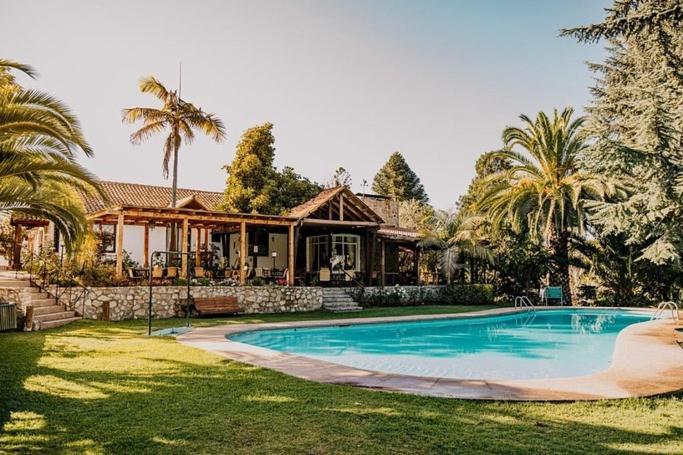 a house with a swimming pool in front of a house at Hotel Fundo Las Tortolas in Limache