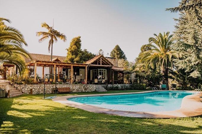 una casa con piscina frente a una casa en Hotel Fundo Las Tortolas, en Limache