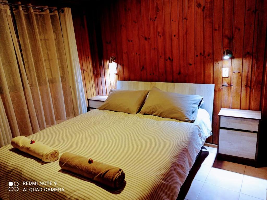 a bedroom with a large bed with wooden walls at Suite Loreto in Caldera