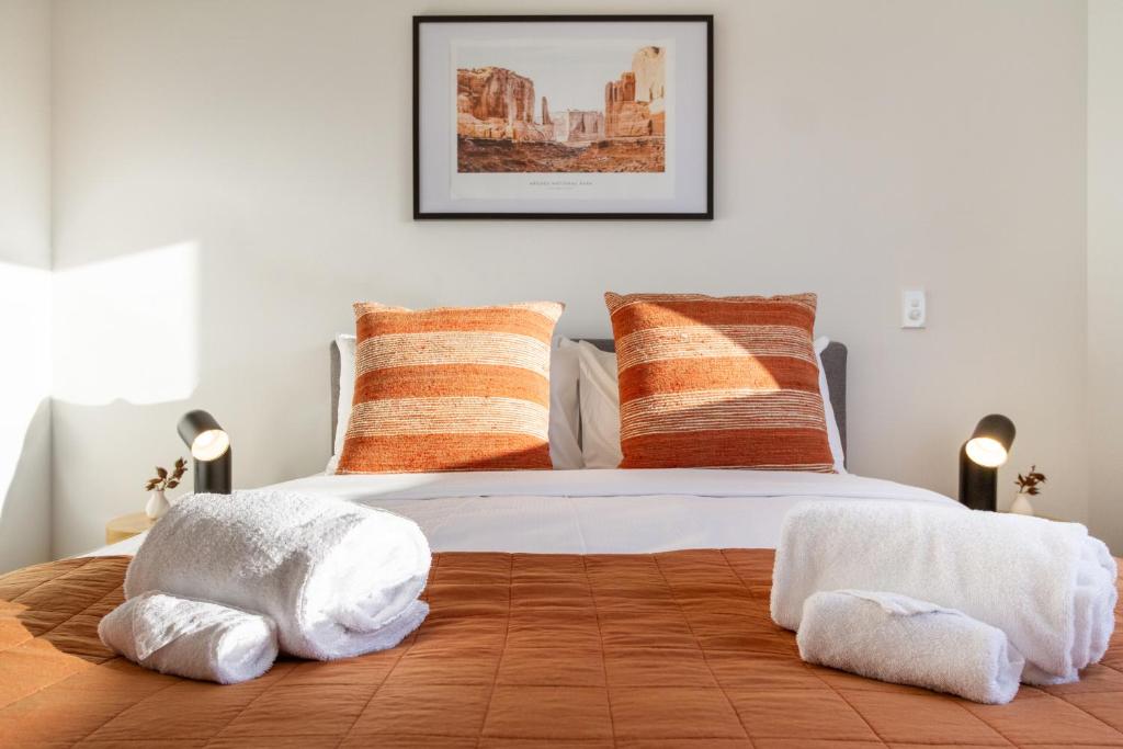 ein Schlafzimmer mit einem Bett mit weißen Handtüchern darauf in der Unterkunft Garden City Getaway 2 bed with sofa bed 1 bath in Christchurch