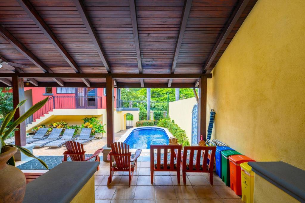 une terrasse avec une table et des chaises ainsi qu'une piscine dans l'établissement Jade Coast #3- Private 5 Bedroom Villa, à Tamarindo