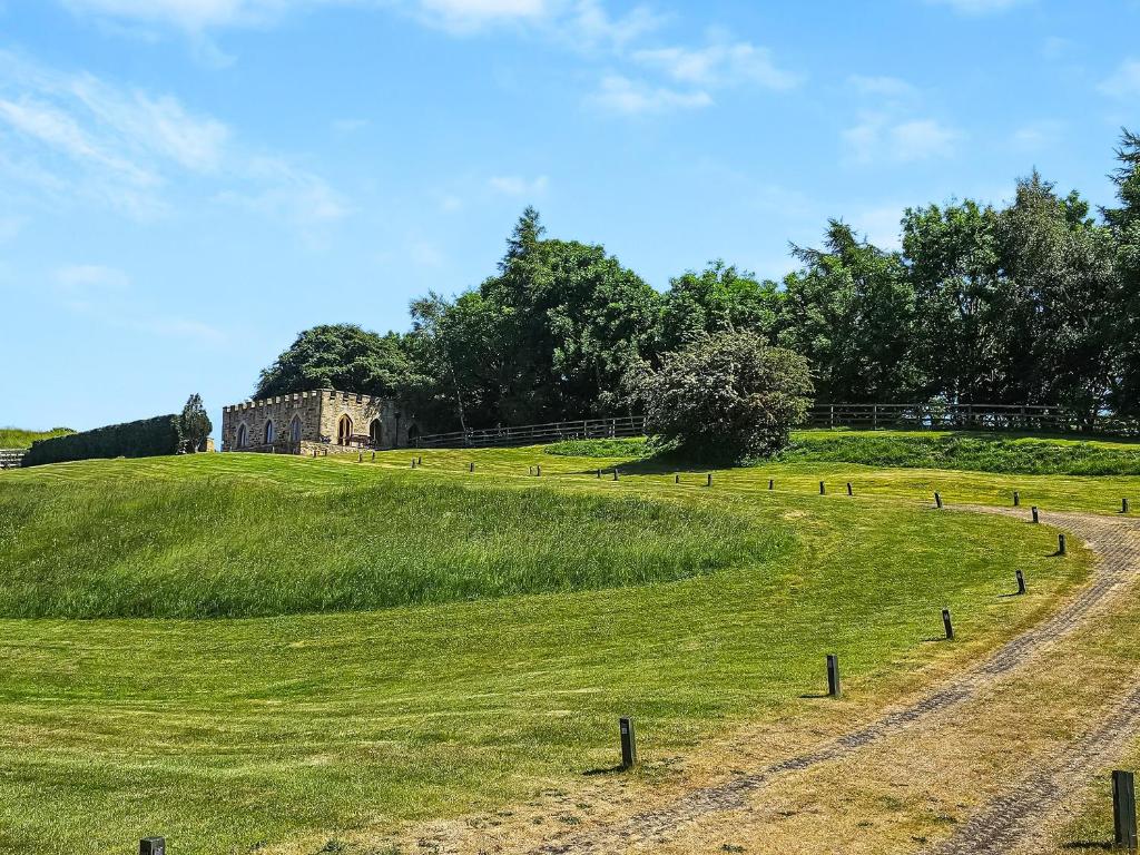 a dirt road in a field with a castle in the background at The Water Castle in Wall Houses