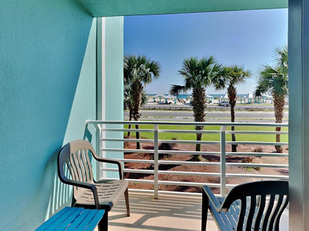 balkon z 2 krzesłami i widokiem na plażę w obiekcie Palm Beach Club 125 w mieście Pensacola Beach