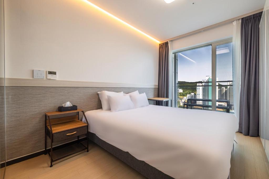 a hotel room with a large bed and a window at Skytop Hotel Incheon Airport in Incheon