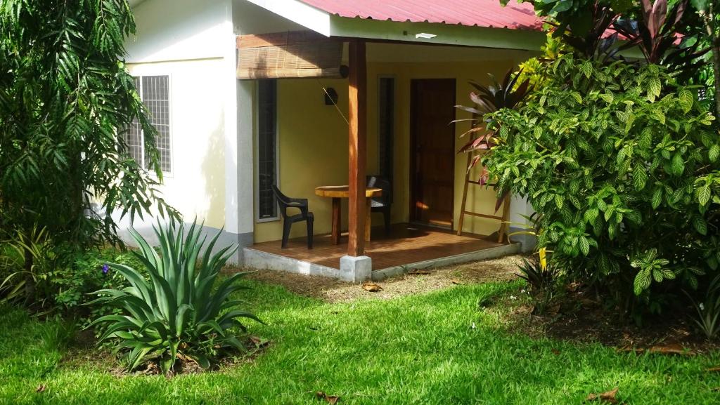 a small house with a porch with a table at ACACIA'S Cottages mit Starlink Wifi in Mambajao