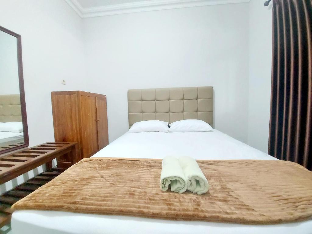 Un dormitorio con una cama con una toalla. en Hotel Sri Timur, en Timuran