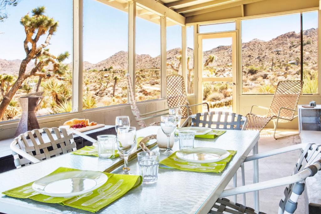 a dining room with a table with a view of the desert at Joshua Tree Dream Weaver hot tub & National Park in Joshua Tree