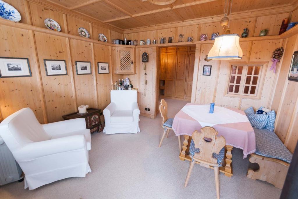 ein Esszimmer mit einem Tisch und Stühlen sowie Holzwänden in der Unterkunft Modern Living Traditional Style in Altenmarkt im Pongau