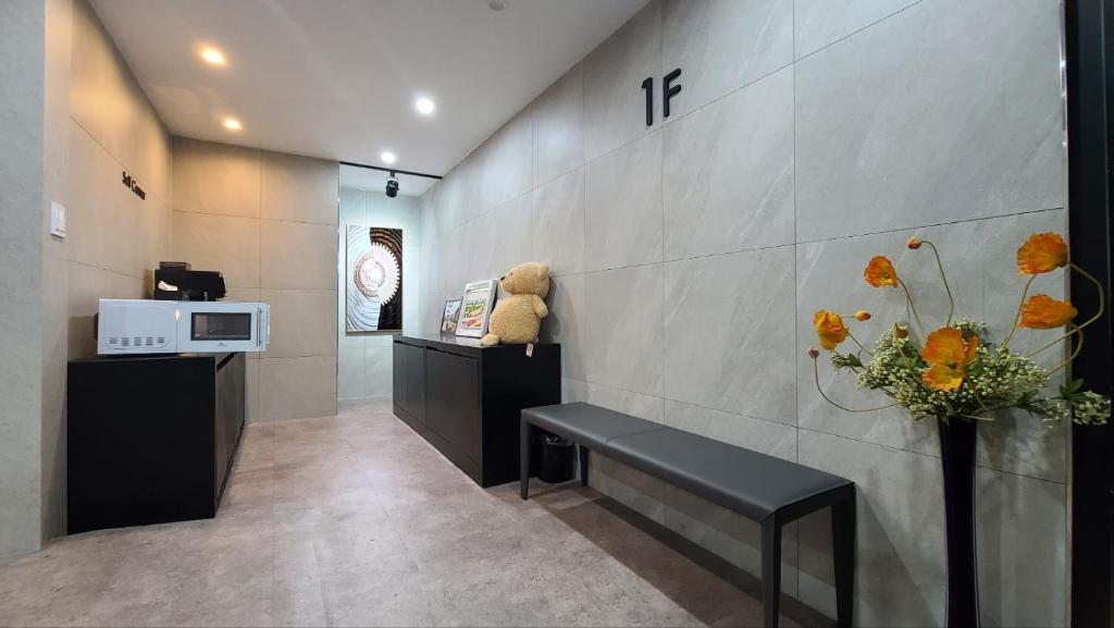 una sala de espera con banco y microondas en Namuneulno hotel, en Busan