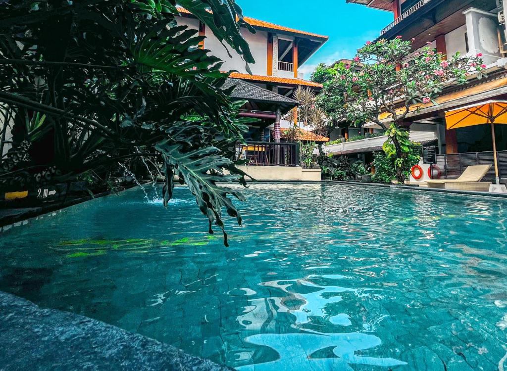 a swimming pool in front of a building at Bali Summer Hotel by Amerta in Kuta